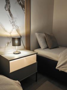 1 dormitorio con 2 camas y mesita de noche con lámpara en Villa Bella, en Orechová Potôň