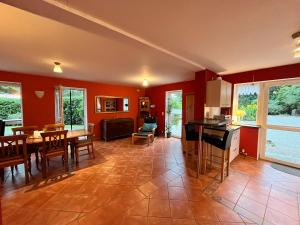 a kitchen and dining room with red walls at Cattle Barn - leben auf dem Hof in Tröndel