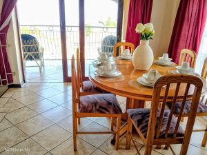 a dining room table with chairs and a vase on it at Sombedu Guest Suite - Sea View Apartment in Margate in Margate