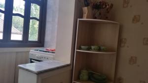 a kitchen with a refrigerator and a stove and a window at Anis 1 in Khujand