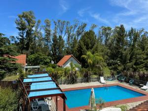 a swimming pool in front of a house with trees at Bellamar Apart Hotel in Bella Vista