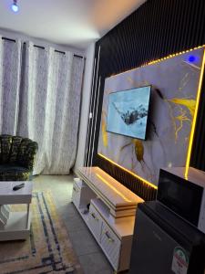 ナイロビにあるNGT Luxury homesの壁にテレビが取り付けられたリビングルーム