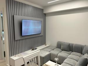 un salon avec un canapé et une télévision à écran plat dans l'établissement Aleas Apartments, à Durrës
