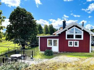 ein rotes Haus mit einem Picknicktisch davor in der Unterkunft 4 person holiday home in UDDEVALLA in Uddevalla