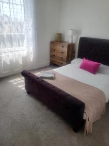 a bedroom with a large bed with a pink pillow at Seashore Sunrise Apartment in Herne Bay