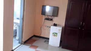 a room with a refrigerator and a tv on the wall at 7B Hotel in Addis Ababa