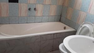 a bathroom with a bath tub and a toilet at 7B Hotel in Addis Ababa