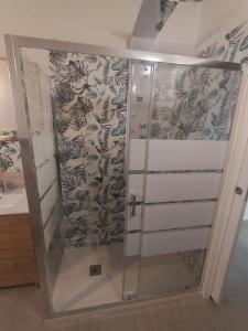 una ducha con puerta de cristal en un baño en Casa Verde, en Capannori