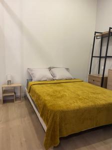 een slaapkamer met een bed met een gele deken bij Lou Occitan in Béziers