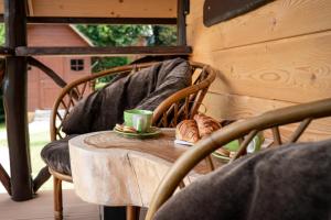 a table with a coffee cup and croissants on a porch at Domek za Księżycem - azyl z balią, kominkiem i prywatnym ogrodem, Ustroń in Ustroń