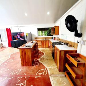 a large kitchen with wooden cabinets and a stove at Family House with Private Pool in Chachagua