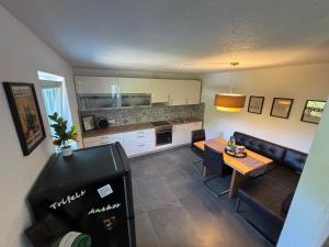 a small living room with a table and a kitchen at Pfalzliebe in Rinnthal