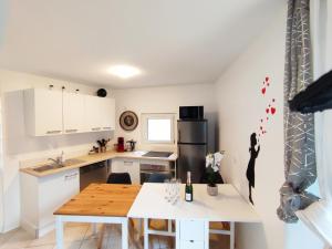 a kitchen with white cabinets and a wooden table at Space House & Surprise - Disneyland & Paris in Chalifert