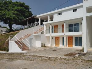 a white house with a staircase in front of it at Samaná Suites Hotel by Habita in Santa Bárbara de Samaná
