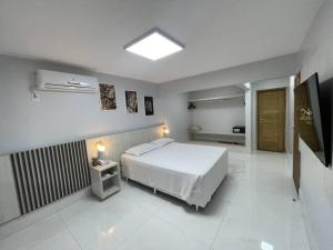 una camera da letto con un letto bianco in una stanza di CALDAS NOVAS - COM ACESSO GRATUÍTO Ao ACQUA PARK a Caldas Novas