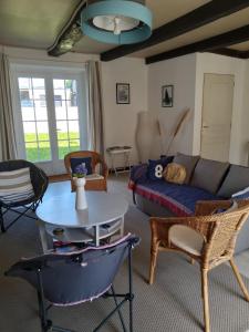 a living room with a couch and a table at Kerfly in Plouër-sur-Rance