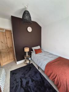 Un dormitorio con una cama y un reloj en la pared. en Bronferen, en Bridgwater