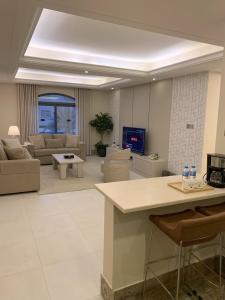een grote woonkamer met een bank en een tv bij Alarjan Dream in Riyad