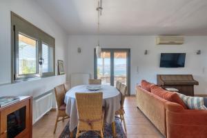 een eetkamer met een tafel en een bank bij Finca Nafplio Hills, spectacular sea view in Nafplio +31 foto's