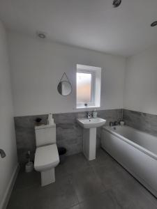a bathroom with a toilet and a sink and a tub at Kimberworth Family Stay in Kimberworth +21 photos