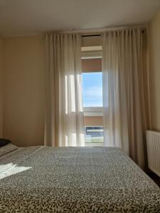 a bedroom with a bed and a large window at Apartament Potockiego Private Parking Faktura in Rzeszów