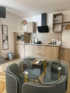 a room with a glass table and a kitchen at El Doce Del Ferial in Solares +5 photos