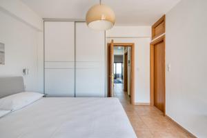 een slaapkamer met een wit bed en een glazen wand bij Finca Nafplio Hills, spectacular sea view in Nafplio