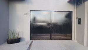 a metal door in a building with a plant at AP 5 C/Garagem>Ar>Wifi>Cozinha>Tv Disney+>Pet free in Ji-Paraná