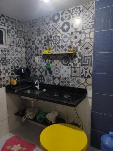 una cucina con un tavolo giallo e uno sgabello giallo di Flat 23, Condomínio Manguezal a Porto De Galinhas