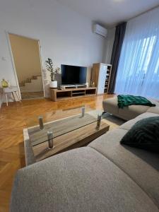 a living room with two beds and a flat screen tv at Central Terrace Apartment in Nové Zámky