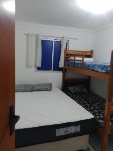 una camera da letto con due letti a castello e una finestra di Flat 23, Condomínio Manguezal a Porto De Galinhas