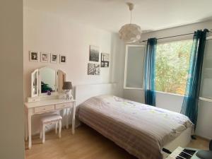 ジニャックにあるMaison agréable proche de Saint Guilhem-le-Desert 2 chambresのベッドと机と鏡のある寝室