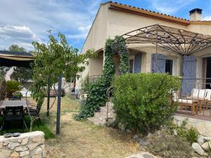 ジニャックにあるMaison agréable proche de Saint Guilhem-le-Desert 2 chambresのピクニックテーブルとパティオ付きの家