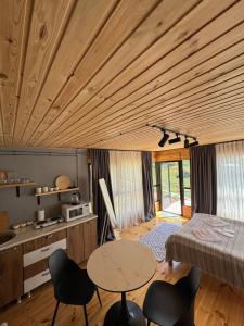 a room with a wooden ceiling with a table and chairs at Khedi in Jut'a