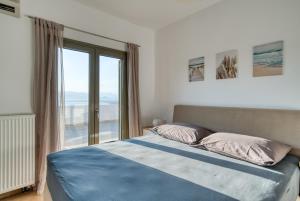 een slaapkamer met een bed en een groot raam bij Finca Nafplio Hills, spectacular sea view in Nafplio