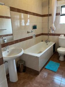 een badkamer met een bad, een wastafel en een toilet bij The L Suite Apartment in Nairobi