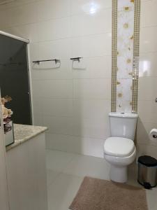 a white bathroom with a toilet and a shower at Quarto suíte privativa in Xaxim +10 photos