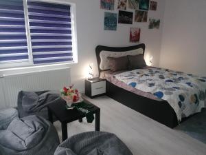 a bedroom with a bed and a chair and a table at Art Studio BN - Create Your Own Fluid ART Masterpiece! in Bistriţa