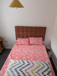 a bedroom with a bed with a pink bedspread at Rossetti in Bristol