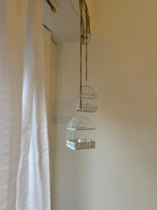 een vogelkooi die aan een muur hangt naast een gordijn bij Alfonsina Departamento cerca del mar in Mar del Plata