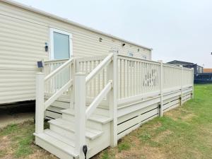 a house with a white staircase next to a building at Pebbles in Selsey