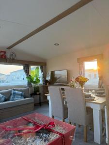 a living room with a couch and a table with chairs at Pebbles in Selsey