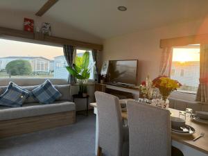 a living room with a couch and a table at Pebbles in Selsey