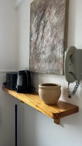 een houten plank met een kom en een telefoon aan de muur bij Alfonsina Departamento cerca del mar in Mar del Plata