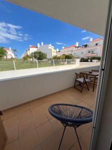 a balcony with a blue chair and a table at Cabanas De Miramar in Tavira