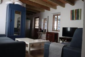 a living room with a blue couch and a tv at Authentic fisherman's house Maison de pêcheur authentique in Port-la-Nouvelle
