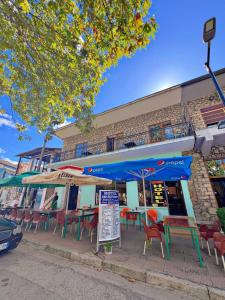 a restaurant with tables and chairs in front of a building at Hotel Restorant JORGO in Leskovik