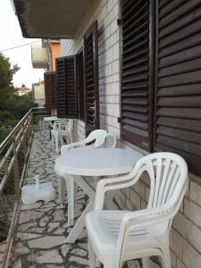 rzędu białych stołów i krzeseł na patio w obiekcie Berto w mieście Nerezine