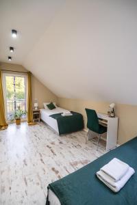 a bedroom with two beds and a desk and a window at Oskarówka Kaszuby z balią in Gołubie +24 photos