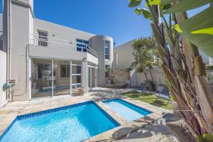 a swimming pool in front of a house at White Waters in Cape Town